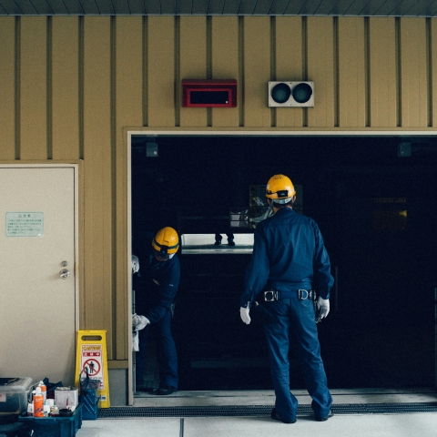 People in safety equipment working in a hall